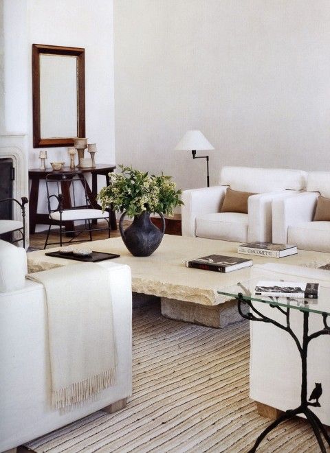 a neutral living room with creamy furniture, a low stone slab coffee table, elegant dark touches for a contrasting look
