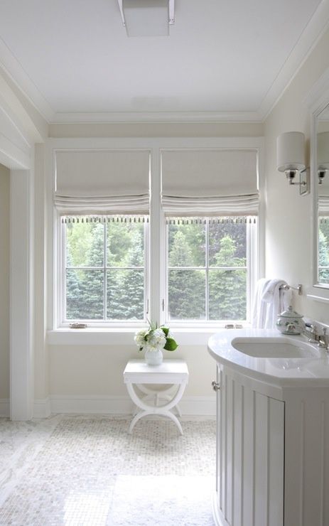 a refined white bathroom with white Roman shades with tassels are a beautiful and cozy addition that highlights the elegance of the space