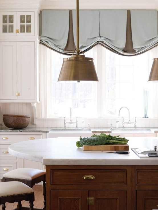 blue and brown Roman shades accent the rustic kitchen and add color to the space matching the brass lamps that wow the kitchen