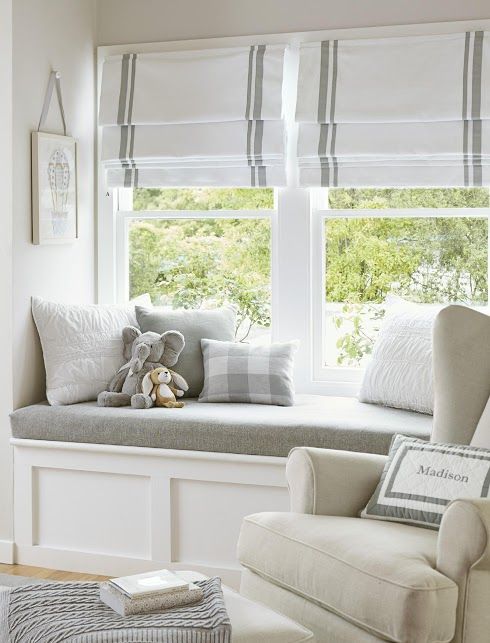 a beautiful windowsill nook styled with striped Roman shades, with a windowsill daybed and pretty neutral pillows is cool for a kid's or some other room