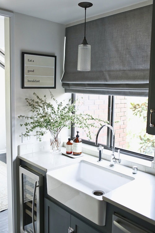 a graphite grey Roman shade is a perfect idea for a Scandinavian kitchen and it makes the space more welcoming and private