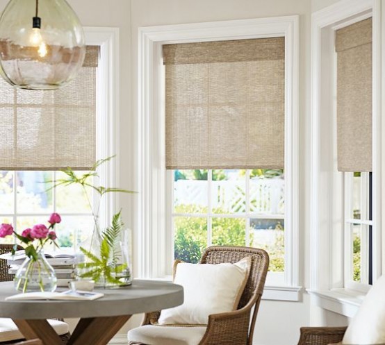 burlap Roman shades on a bay window will stick to your rustic or farmhouse style and will make the space look cozier and cooler