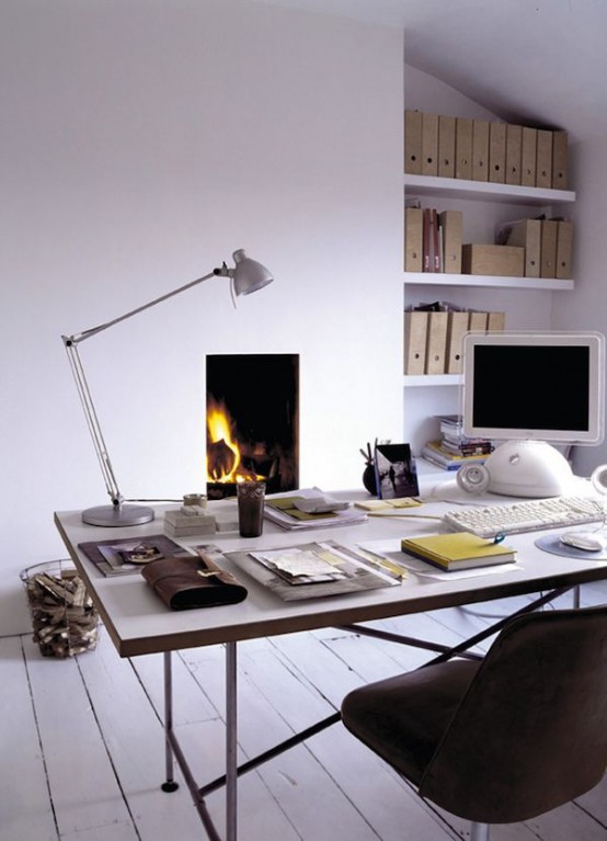 a white Nordic home office with lots of built-in bookshelves, a fireplace, a large desk and a black chair, a silver table lamp is a beautiful space