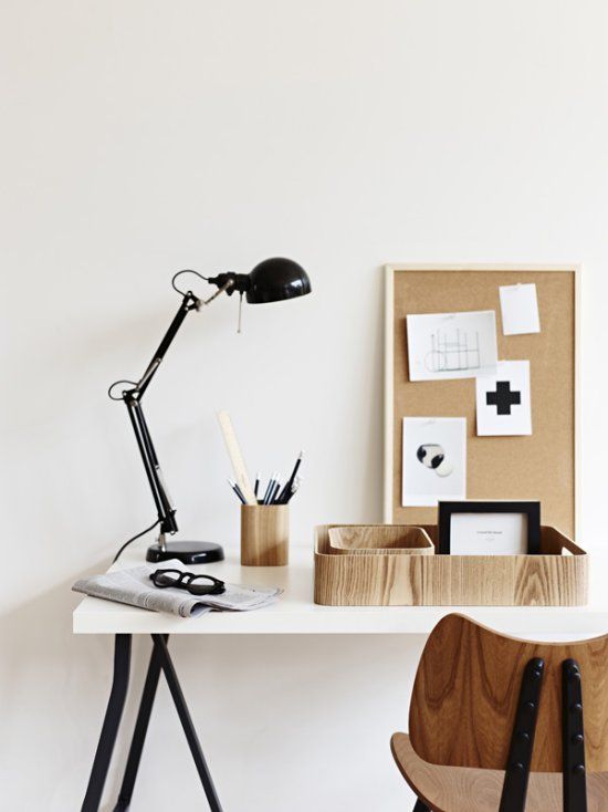 a neutral Scandi home office nook with a black and white trestle desk, a plywood chair, a memo board and a black table lamp