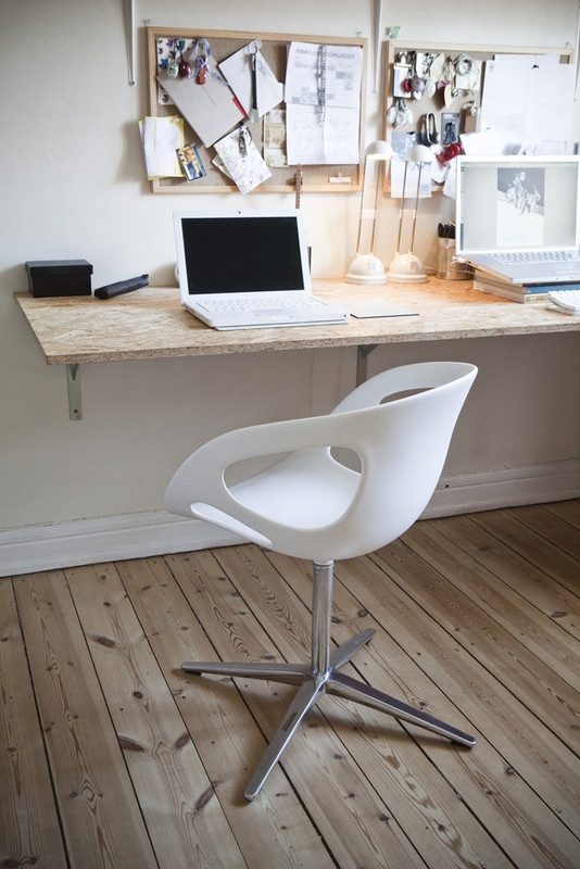 a Scandinavian home office in neutrals, with a memo board, a wall-mounted desk, a white chair, some art and other stuff