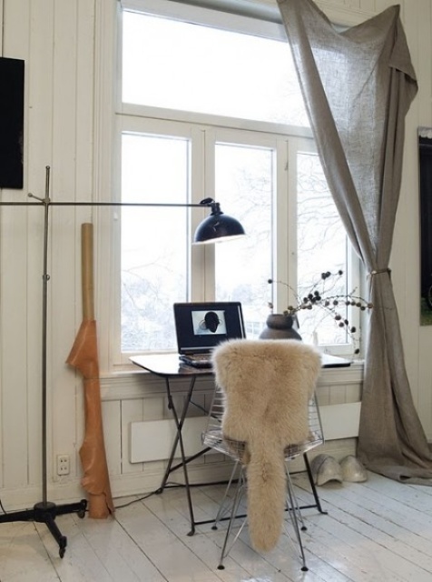 a Nordic home office with a vintage touch, with a small black desk and a metal chair, a black table lamp and grey curtains