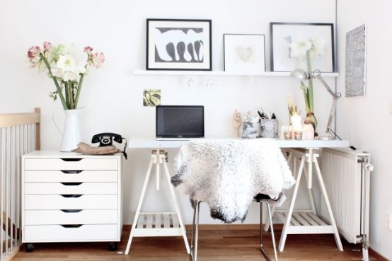 a white Scandinavian home office nook with a trestl desk, a chair, a gallery wall and a small file cabinet is a lovely space