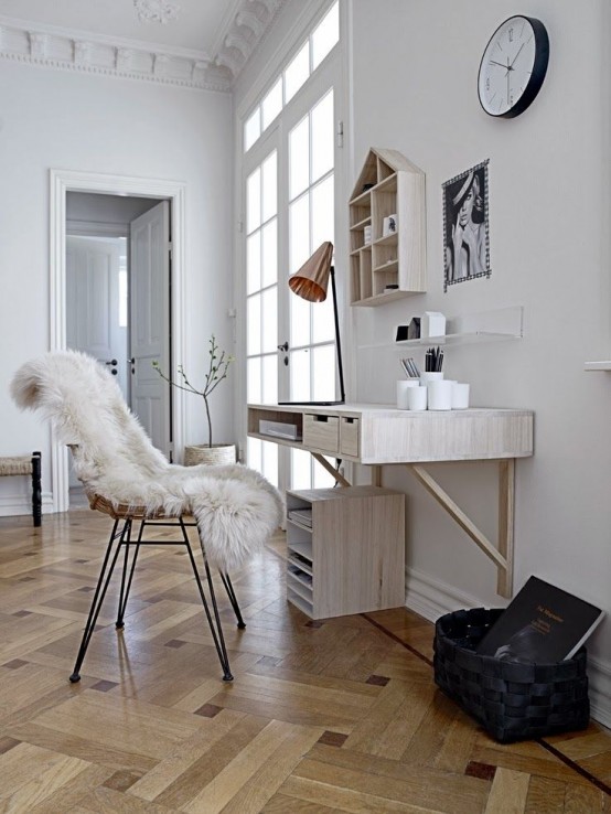 a Nordic white home office with a wall-mounted desk, a cabinets for storage, a house-shaped wall-mounted shelf and a cane chair