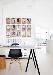 a small Scandi home office nook with a black and white trestle desk, a black chair, a memo board a white file cabinet and a basket for storage