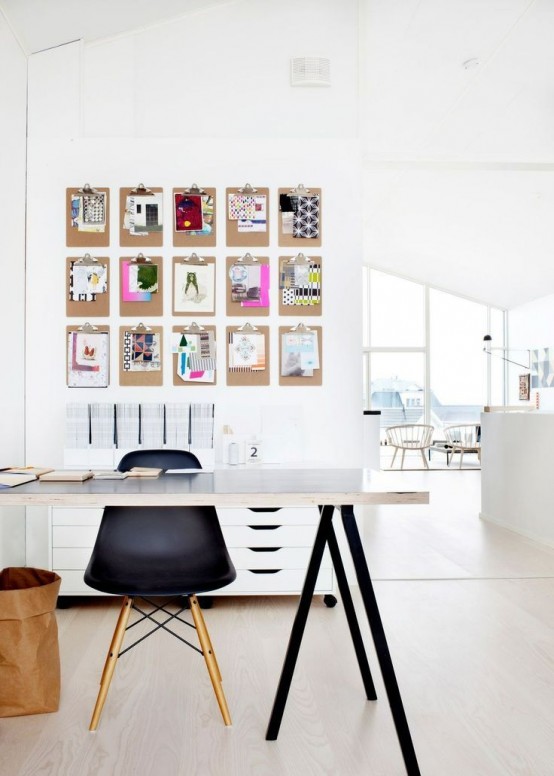 a small Scandi home office nook with a black and white trestle desk, a black chair, a memo board a white file cabinet and a basket for storage