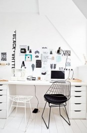 a black and white attic home office with a white desk, black and white chairs, a gallery wall and lots of natural light incoming