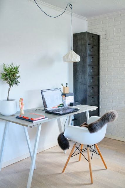 a minimal Nordic home office with a metal file cabinet, a white desk and a white chair, a faceted pendant lamp and a potted plant