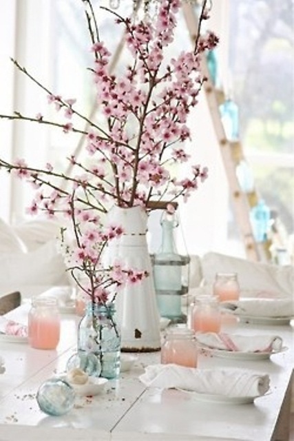 a neutral spring tablescape with ombre peachy pink jars, blue vases and blooming cherry branches