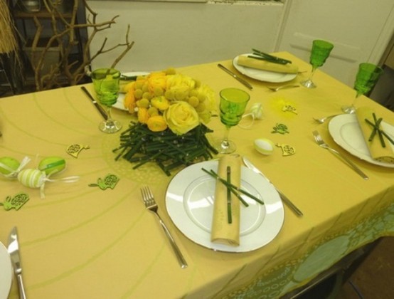 a hot yellow spring tablescape with a bright tablecloth, yellow roses and napkins