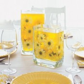 a cheery sprign centerpiece with glasses filled with yellow water and blooms to add color