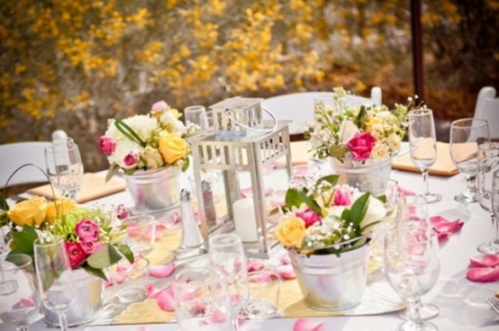 add color to your table setting with bright floral centerpieces in buckets for a rustic feel