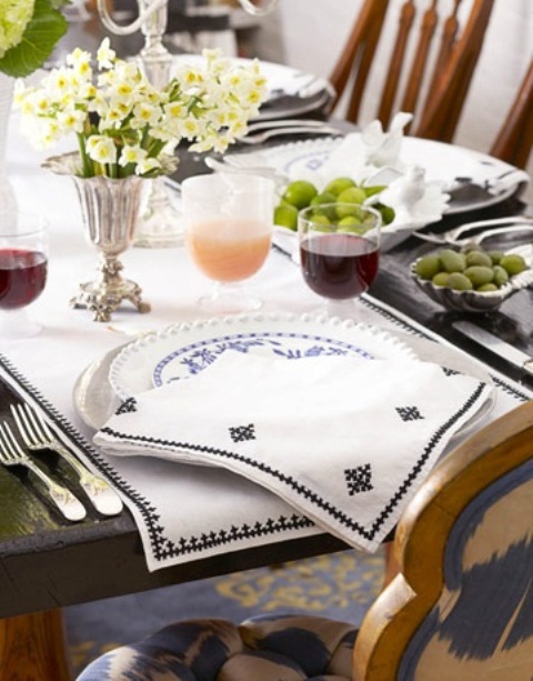 a simple spring palce setting with printed porcelain and napkins, with a fresh bloom centerpiece