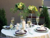 a chic spring tablescape with green and yellow centerpieces, green napkins and candles