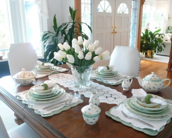 a fresh green and white spring tablescape with lace runners and placemats and a white tulip centerpiece