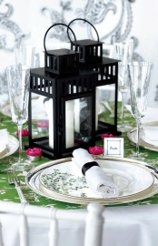 a colorful place setting in green, pink and with candle lanterns