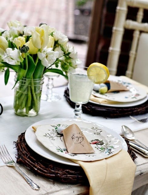 a vintage inspired place setting with a vine charger, a tulip centerpiece and patterned porcelain
