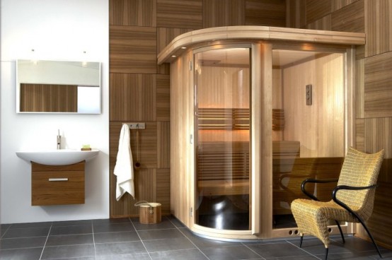a tiny steam room clad with wood and glass, with a single wooden bench and some built-in lights
