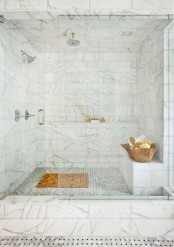 a refined white marble steam room with a tile clad bench and shelf and wooden bowls with foams and scrubs