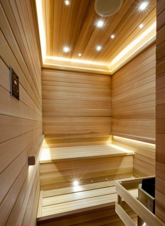 a modern steam room clad with wood, with lots of built-in lights to make the space more welcoming