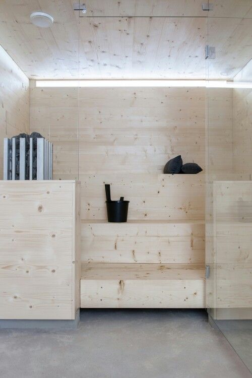 a tiny steam room clad with wood and with step benches plus a narrow skylight for a more natural feel here