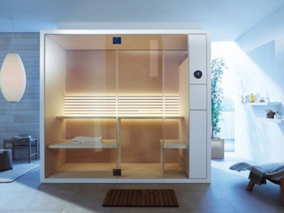 a tiny modern steam room with wood and metal, with several benches for sitting and lying and lights on the wall