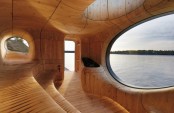 a gorgeous all curved steam room clad with wood, with cavities and several windows and a sew view is an oasis of relaxation