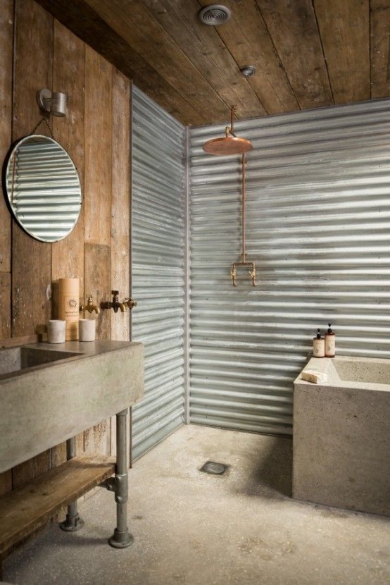 a rustic industrial bathroom with a reclaimed wood ceiling and walls, a concrete floor, a tub and a sink plus corrugated steel walls