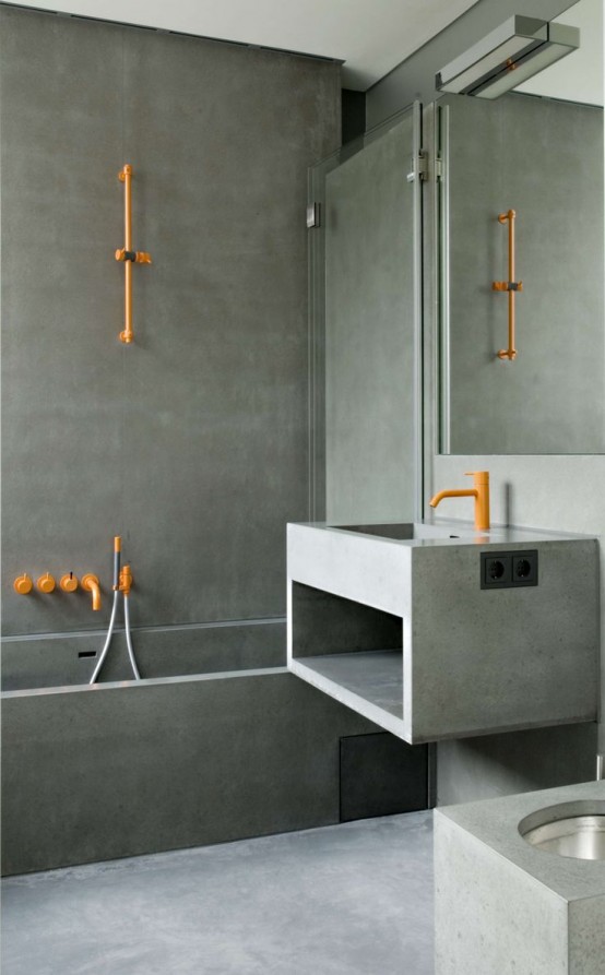 a minimalist concrete bathroom with bold orange fixtures and a mirror plus glass walls is a stylish and elegant idea