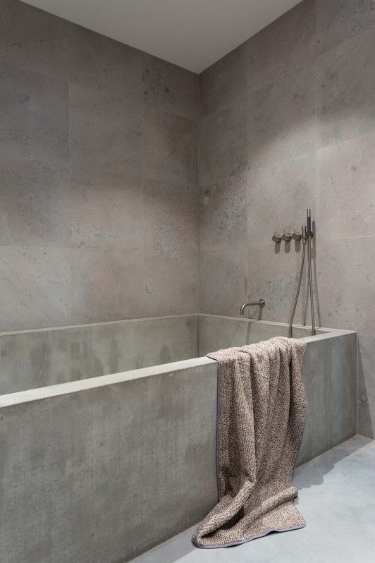 a full concrete bathroom with a concrete bathtub and simple fixtures is a very industrial and at the same time minimalist space