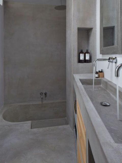 a minimalist concrete bathroom with a built-in tub and a vanity with a double sink in one is rather wabi-sabi