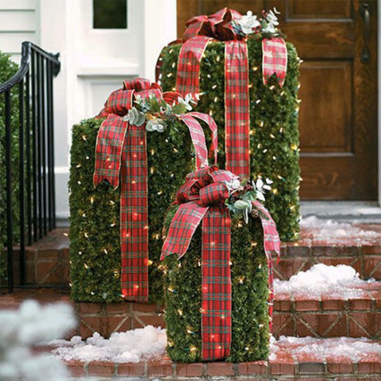 greenery and lights gift boxes with red plaid ribbons and evergreens on top are cool Christmas decor