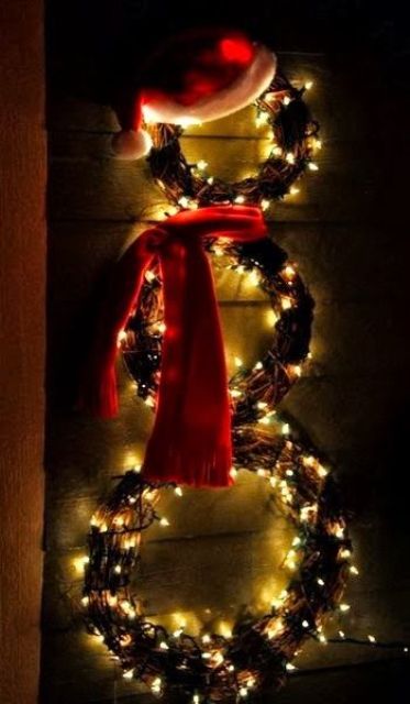 a snowman composed of vine wreaths with lights, a red hat and a red scarf is a lovely and easy to DIY outdoor decoration for Christmas