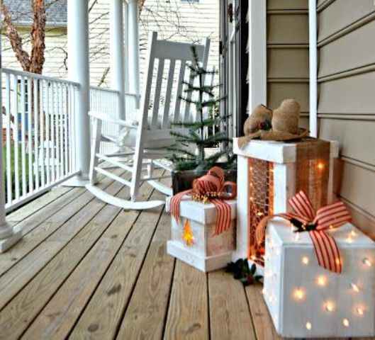 gift boxes with lights and bows on top are amazing to give a cozy festive feel to your porch