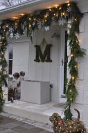 an evergreen and light garland, snowflakes and icicles make the porch very holiday-like and give it a fresh feel