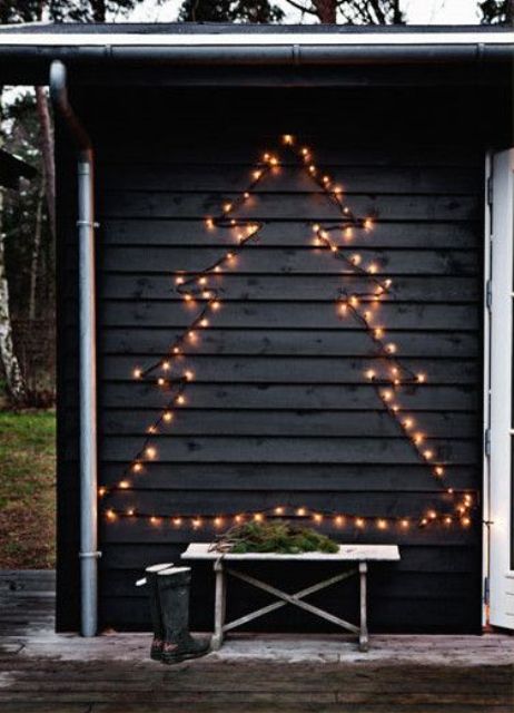 a Christmas tree of lights attached to the wall is a cool outdoor decoration you may rock at holidays