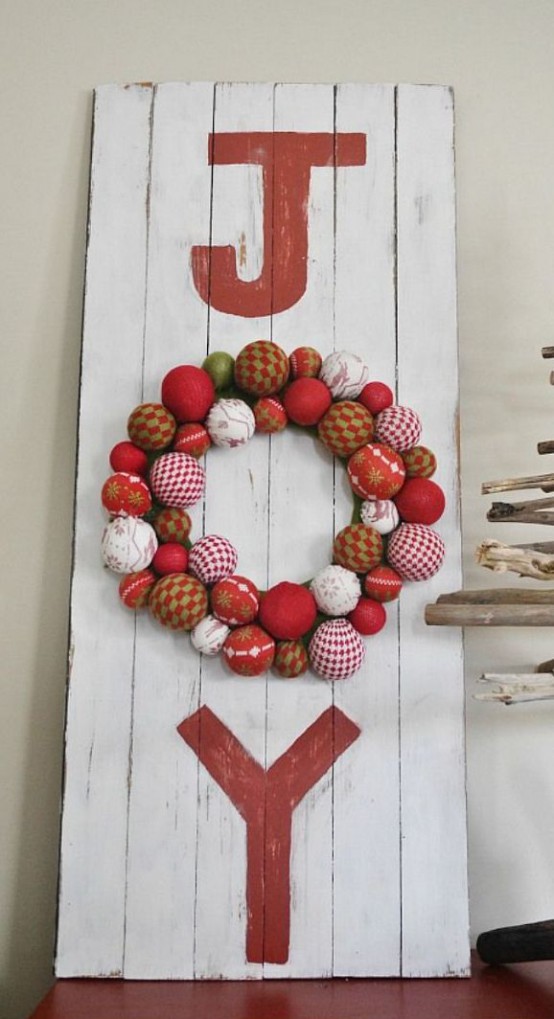 a red and white wooden plaque Christmas sign with red letters and a round O letter composed of Christmas ornaments in red and white