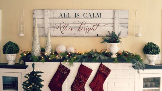 a shabby chic whitewashed Christmas sign attached over the mantel gives it a lovely and cozy look and make the space more welcoming