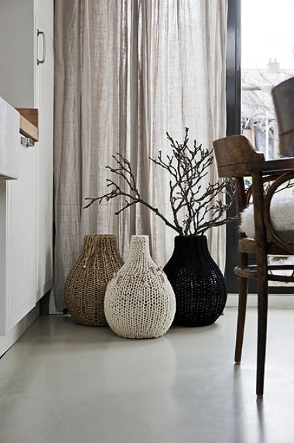large scale vases covered with tan, white and black crochet covers look very chic, cozy and nice and add interest to the space while keeping the color scheme monochromatic