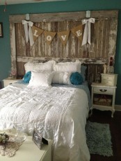 a shabby chic bedroom with emerald walls, a shabby wooden board, refined white furniture, neutral bedding