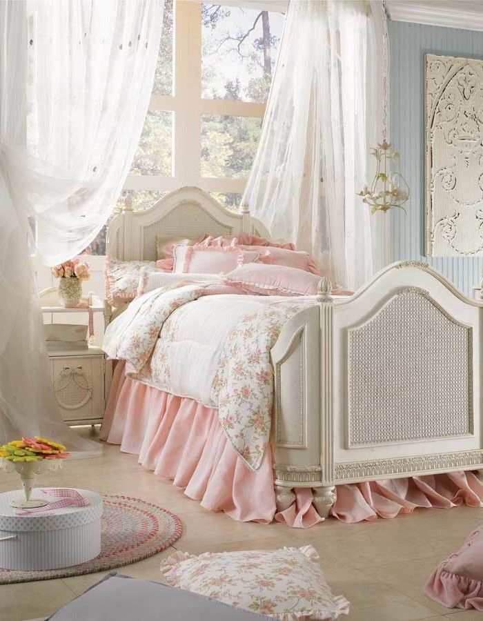an elegant vintage to shabby chic bedroom with pastel blue walls, refined neutral furniture, blush and floral bedding and airy curtains