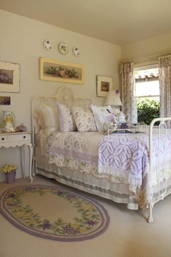 a neutral and pastel bedroom with a white forged bed and refined wooden furniture, lilac and floral bedding and a beautiful gallery wall