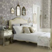 a lavender, white and gold vintage bedroom with printed wallpaper, chic and elegant furniture, a gallery wall and shiny metals