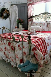 a vintage bedroom decorated for Christmas, with a forged bed, a blue door, greenery, fir and red and white plaid touches