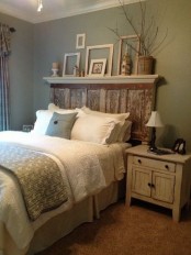 a vintage rustic bedroom with green walls, rustic furniture, green and white bedding, a shelf with frames for decor