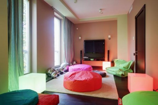 a super bright contemporary space with colorful cushions and pillows plus ottomans and bright curtains to spend time with friends
